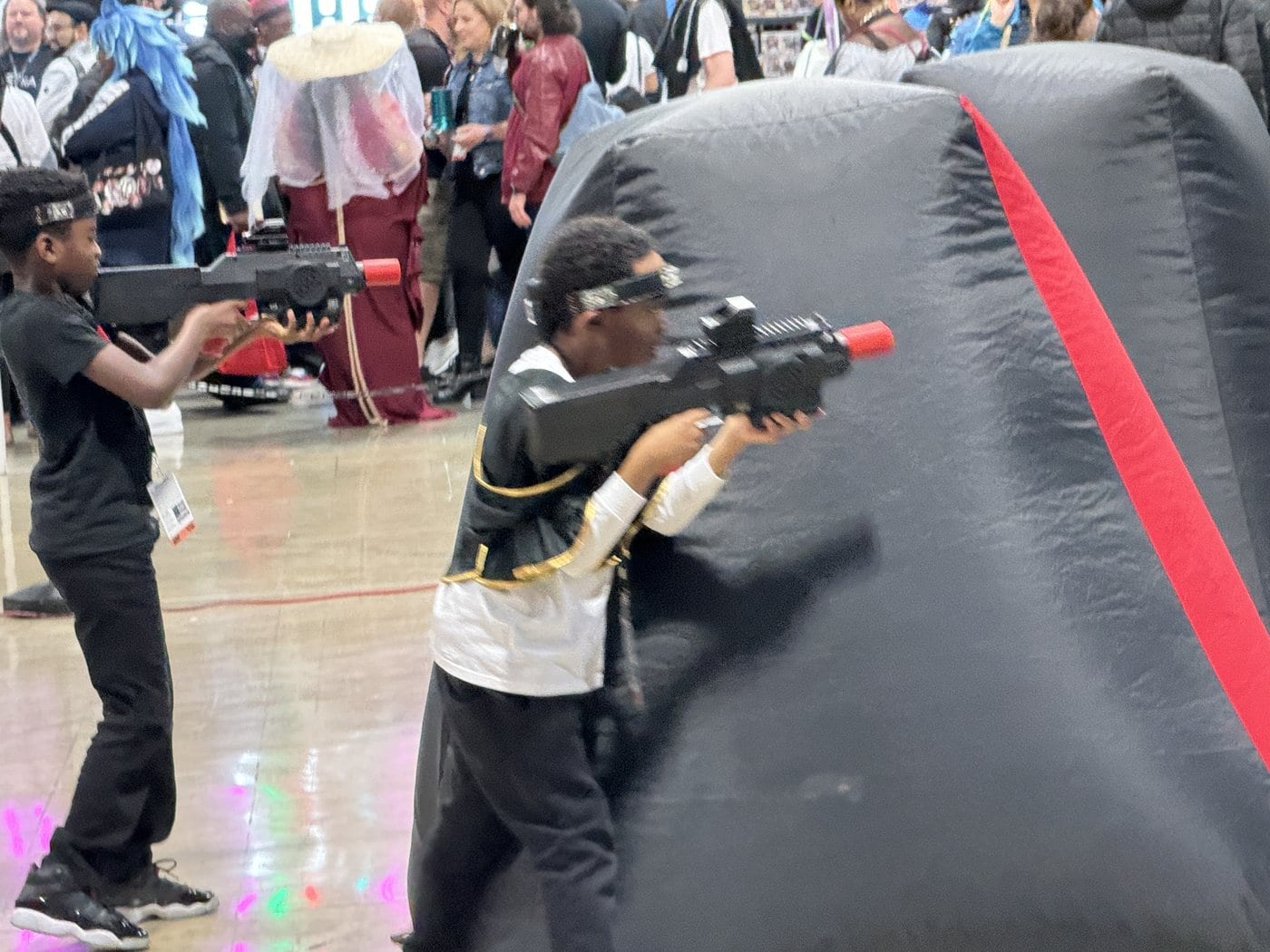 A laser tag round in progress in a DMV gym with inflatable obstacles